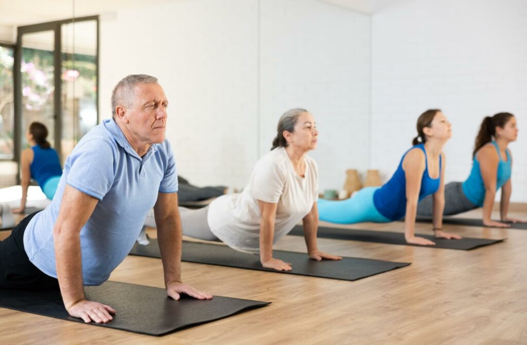 Group of older adults practicing yoga poses on mats to increase flexibility core strength and stability for better balance